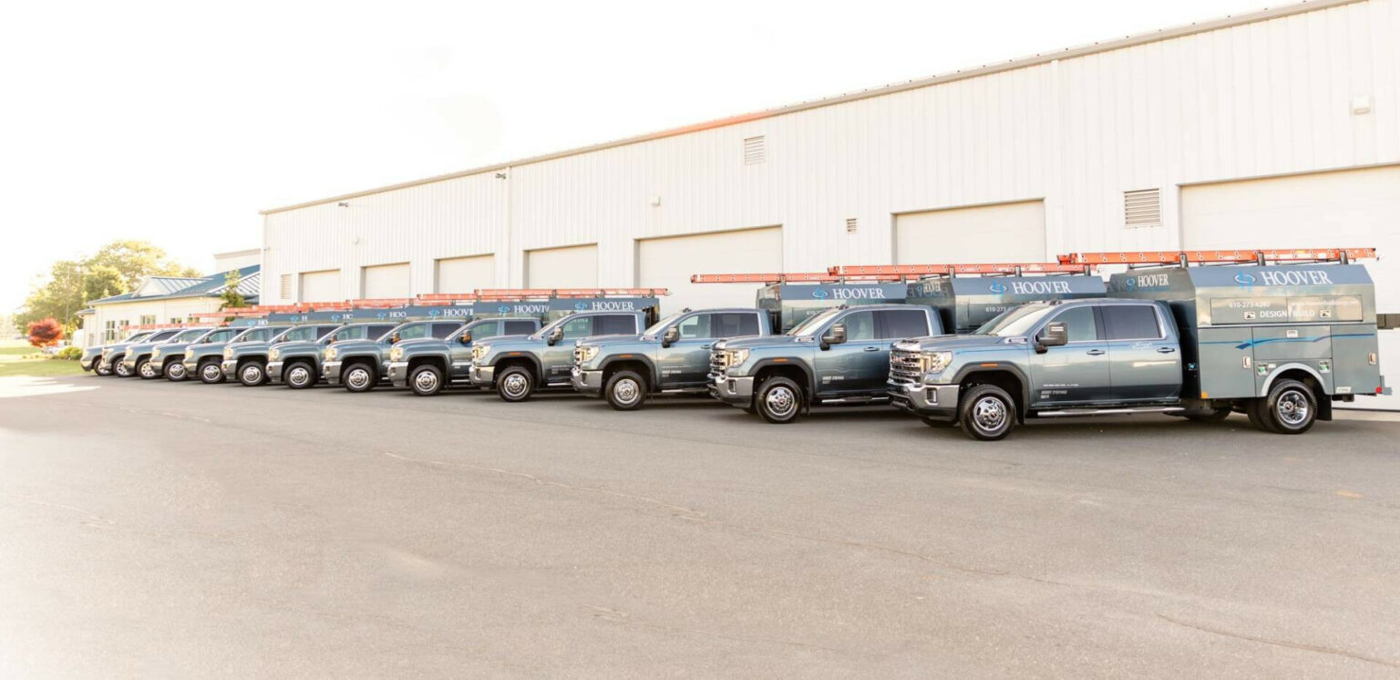 The line of Hoover Building Specialist trucks in front of the shop